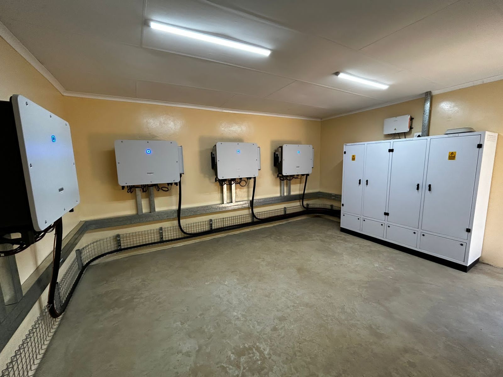 Plant room with wall-mounted inverters and distribution cabinets