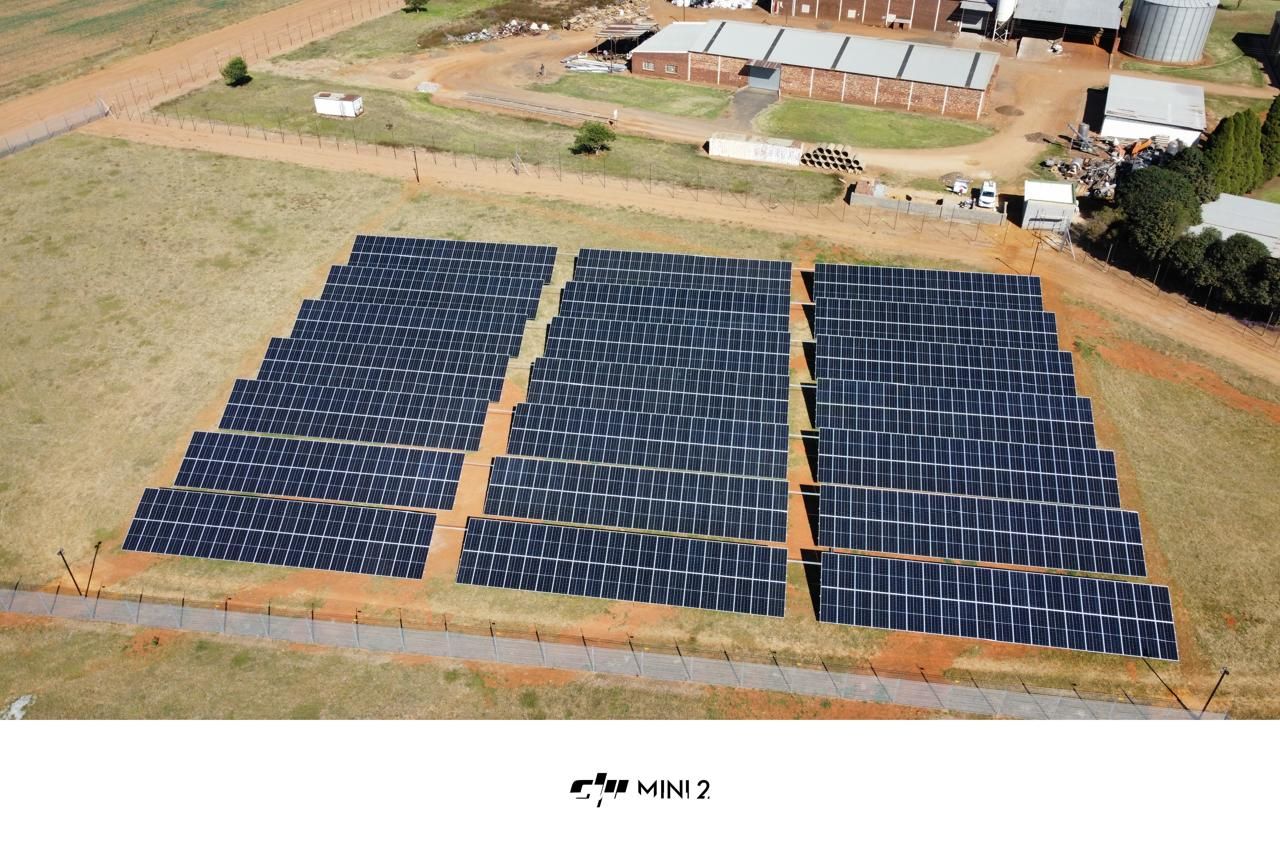 Aerial view of the ground-mounted solar array beside the facility